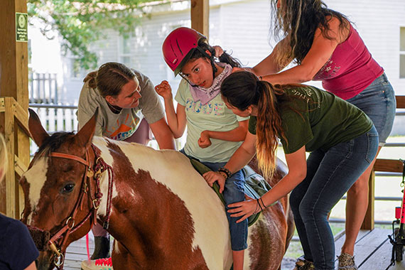 volunteers assisting a rider at Faith Equestrian Therapeutic Center